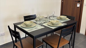 A dining area with a rectangular table set for four, equipped with plates, bowls, and wine glasses. - Oasis of relaxation in the heart of Altavilla Milicia, located between Palermo and Cefalù. (Altavilla Milicia)