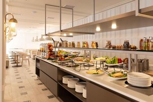 Una barra de buffet con diversos alimentos y acompañamientos.