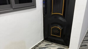 A hallway with a patterned floor and a black door with gold trim. - Cozy 1-bedroom studio in tranquil Weija with AC comfort (Weija)