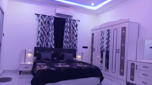 A bedroom with a bed, wardrobe, and nightstands. - Cozy 1-bedroom studio in tranquil Weija with AC comfort (Weija)