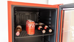 Ett kylskåp med en burk Coca-Cola och flera flaskor.