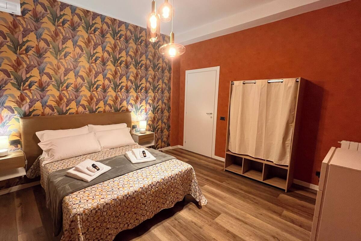 A hotel room with a bed, nightstands, a wardrobe, and a shower curtain.