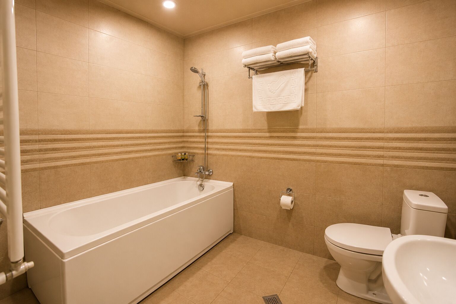 Ein Badezimmer mit Badewanne, Toilette und einem Handtuchhalter mit Handtüchern.