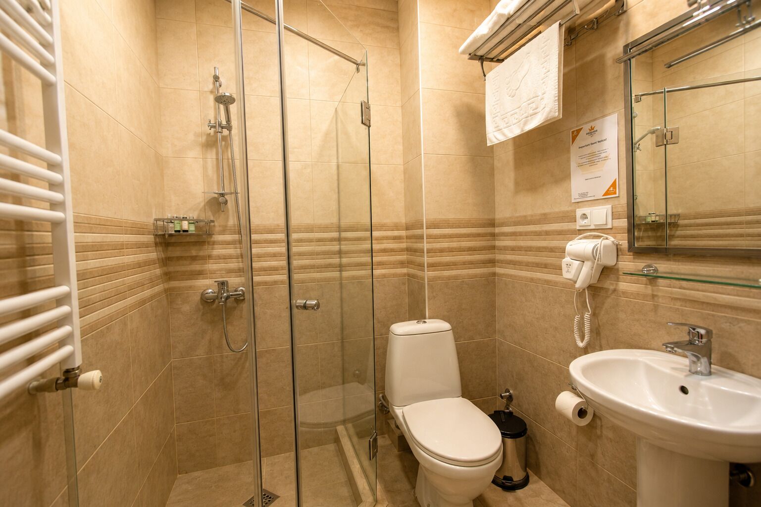 Un baño moderno con cabina de ducha de vidrio, inodoro y lavabo con espejo.