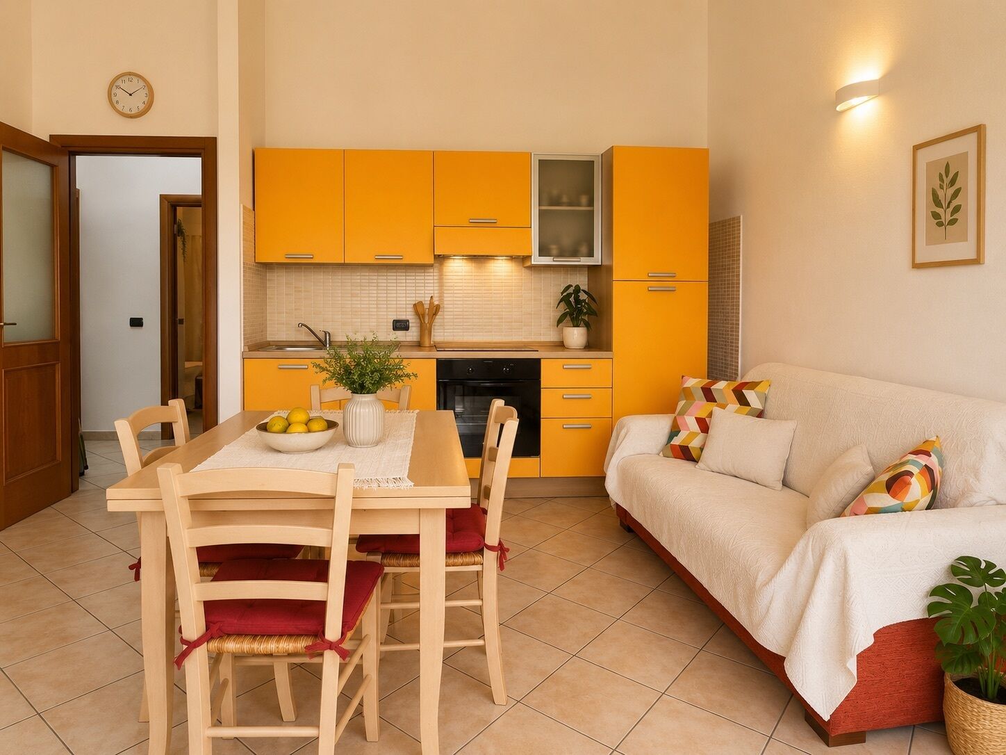 A compact living space with a dining area, kitchenette, and a sofa.