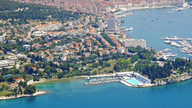 An aerial view of a coastal town with a marina, residential buildings, and a swimming pool complex. - Charming apt With Balcony in the Heart of Split (Split)