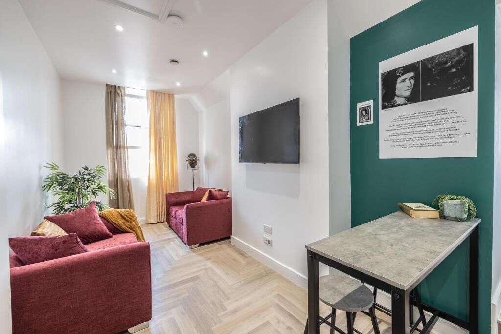Un salon moderne avec un canapé, une table et un téléviseur fixé au mur.