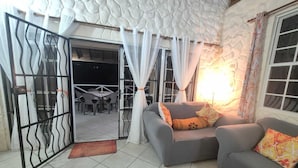 Una sala de estar con un sofá gris, una mesa de centro de madera y un cojín decorativo estampado.