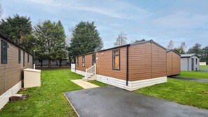 Ein Bungalow mit einer Veranda und einer kleinen angeschlossenen Garage.