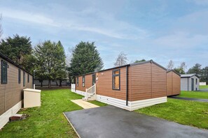 Ein Bungalow mit einer Veranda und einer kleinen angeschlossenen Garage.