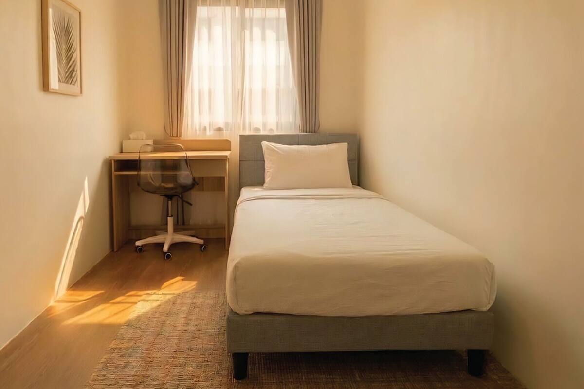 Ein Schlafzimmer mit einem Bett, einem Schreibtisch und einem Stuhl.