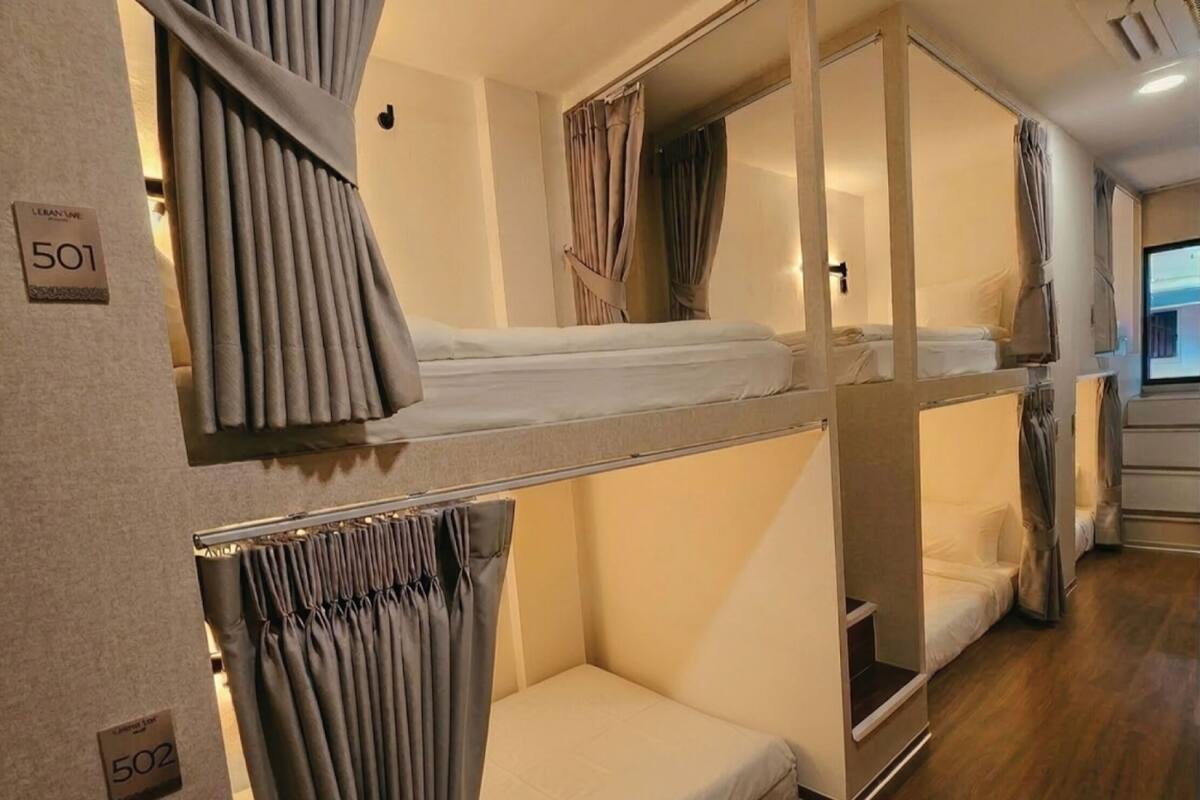 Ein Schlafzimmer mit Etagenbetten, Vorhängen, einem Spiegel und einer Bedienkonsole.