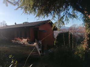 A house with a red exterior, a tiled roof, and a visible staircase leading to the entrance. - Holiday Home 'Vacanze' with Lake View, Wi-Fi and Air Conditioning (Laveno-Mombello)