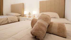 Une chambre d’hôtel avec un grand lit, deux tables de chevet avec des lampes et une tête de lit.
