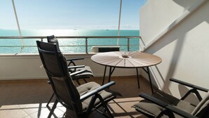 A balcony with a round table and four chairs, overlooking a calm sea with a clear sky. - Greenview Apartment by Tok Apartments (Durrës)