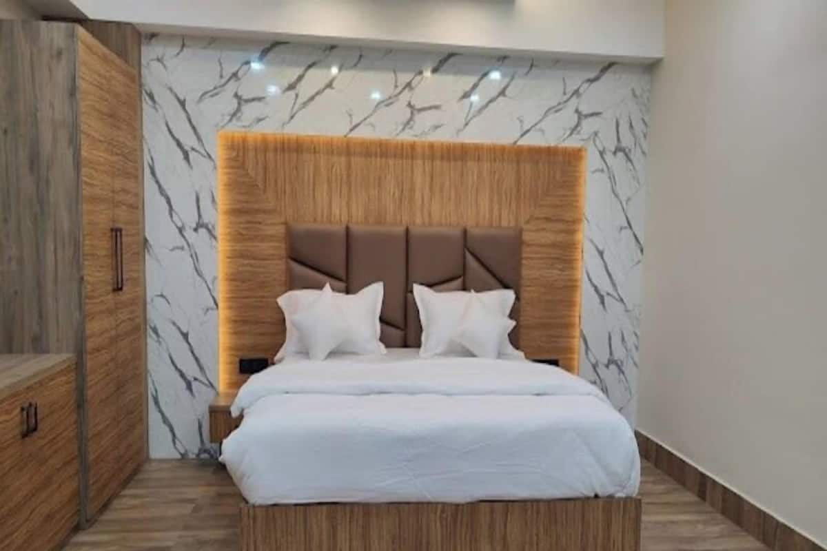 A modern bedroom with a marble-patterned headboard, a wooden bed frame, and a built-in wardrobe.