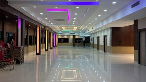 Um corredor amplo com piso lustroso, iluminação embutida e design moderno no teto.