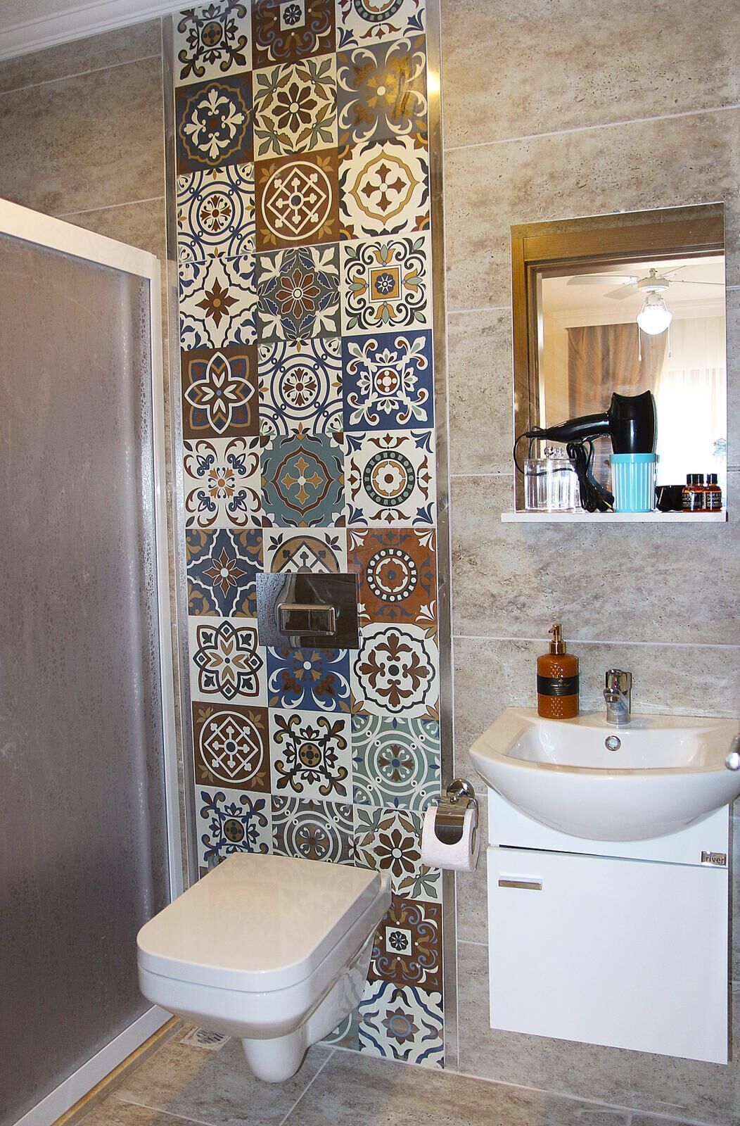 A bathroom with a toilet, sink, and mirror.