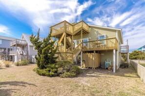 A two-story house with a wooden deck and a staircase leading to a balcony. - Beachside Bungalow - Dog Friendly - Amazing views from rooftop deck! (Topsail Beach)