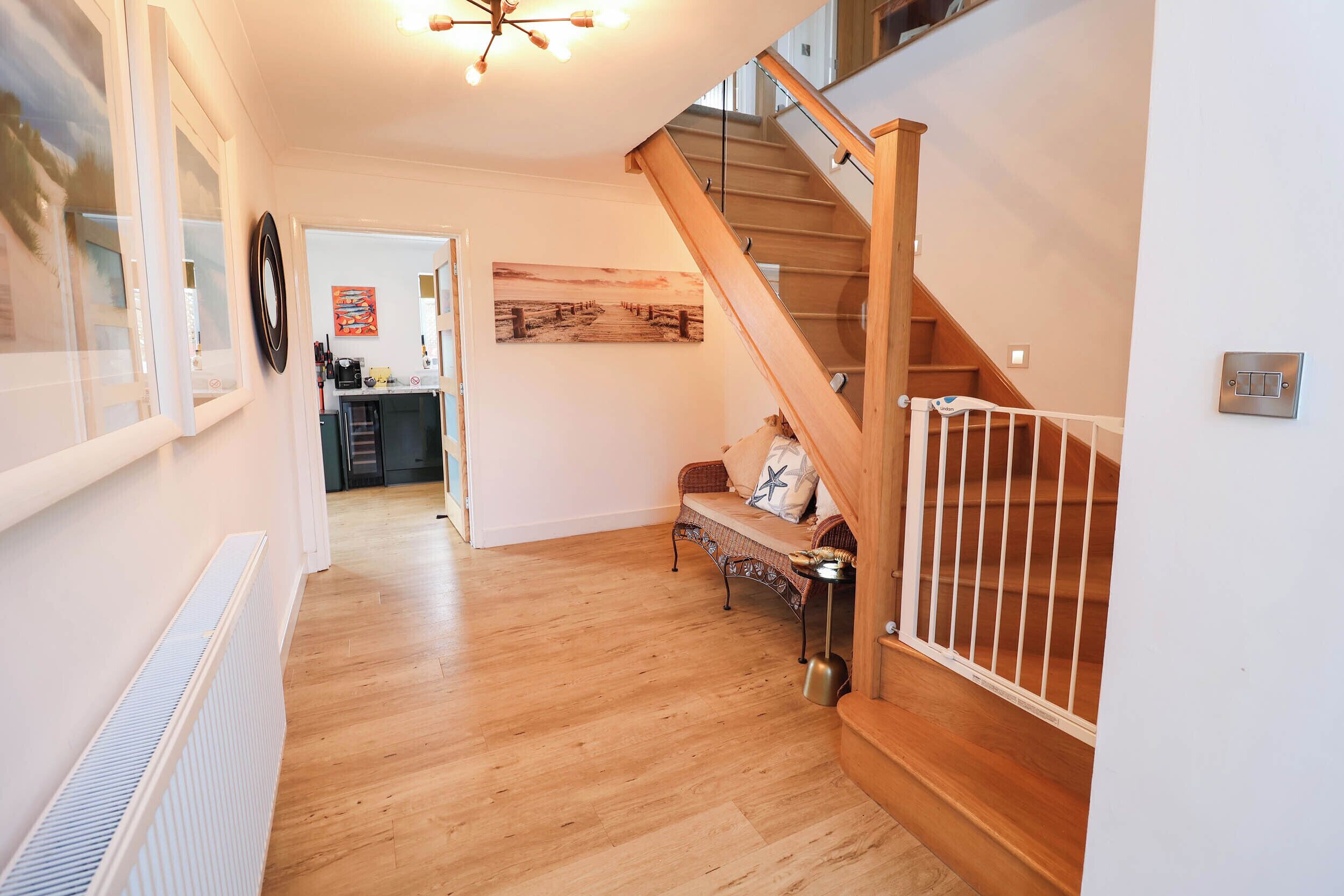 A spacious hallway with a wooden staircase leading to a second floor.