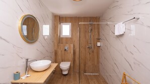 A bathroom with a wooden vanity, a white sink, a toilet, a glass shower enclosure, and a marble wall. - Romantic Leona Apartment with Large Terrace near Dubrovnik (Orašac)