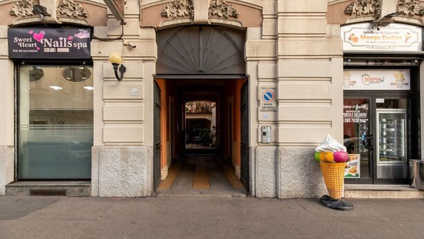 A building facade with a Sweet Heart Nails spa, a Mango Eros center, and a gelateria. - BDC - NoLo Industrial Loft 2Bath (Milan)