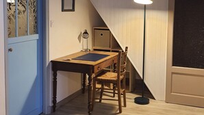 A dining area with a wooden table and chairs, a lamp, and a staircase. - SAUJON APARTMENT NEAR SPA (Saujon)