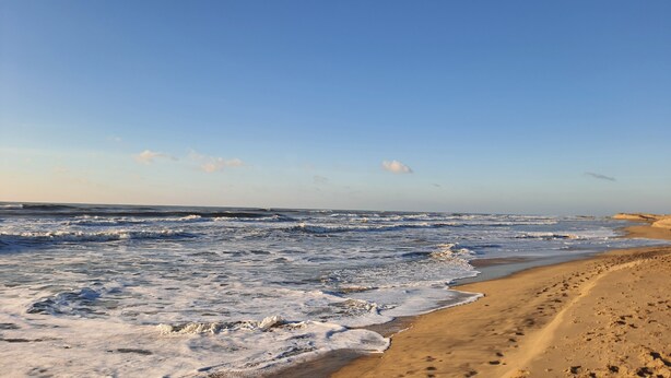 A beach with waves crashing onto the shore, a clear sky, and footprints in the sand. - SAUJON APARTMENT NEAR SPA (Saujon)