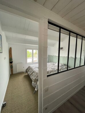 A bedroom with a bed, a window, a radiator, and a door. - 4* House 6 km from Boyardville Beach and 3 km from Dolus   (Dolus d'Oléron)