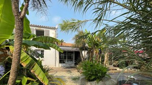 A house with a patio, surrounded by tropical plants and a small pond. - 4* listed house located 6km from Boyardville beach and 3km from Dolus (Dolus d'Oléron)
