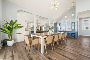 A spacious kitchen with a central island, wooden flooring, and pendant lighting.