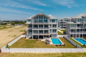A multi-story hotel with a pool area and a beach view. - Stargazer 10 bedroom Brand New Luxury Home on Hatteras Island (Hatteras)