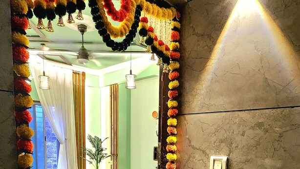 Una habitación con sofá, una mesita de centro y un arco decorativo con guirnalda.