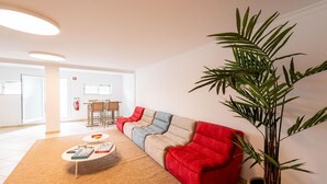En moderne stue med en modulsofa, et sofabord og en stor stueplante.