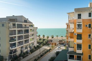 Zona residencial costera con edificios de varios pisos, una playa y cielo despejado.