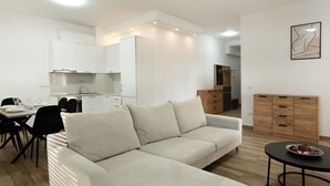 A modern apartment with a dining area, kitchenette, and a living room with a sofa and a small table. - Sea View-Expansive Apartment by TOK (Golem)