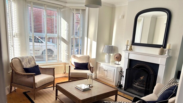 Un salon avec une cheminée, un canapé, un fauteuil et une table basse.