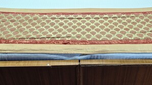 Una cama doble con sábanas blancas y dos almohadas decorativas con estampado de cachemir.