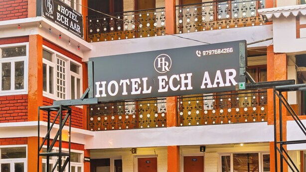 Un hotel de varios pisos con un letrero llamativo que dice "HOTEL ECH AAR".