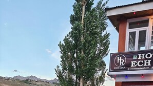 Un hotel con un cartel, un patio empedrado y vistas del paisaje circundante.