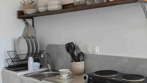 Een kleine keuken met een ingebouwd fornuis, een spoelbak en een compacte koelkast.