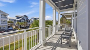 A covered balcony with a view of neighboring houses and a street. - 7BR Heart of Home W Pool Near the Beach (Miramar Beach)