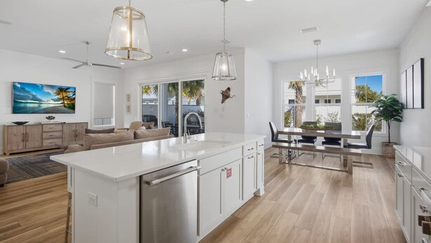 A modern kitchen with a central island, white cabinetry, and pendant lighting. - 7BR Heart of Home W Pool Near the Beach (Miramar Beach)