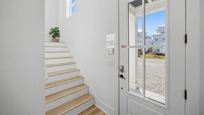 A staircase with wooden steps leading to a white door with glass panels. - 7BR Heart of Home W Pool Near the Beach (Miramar Beach)