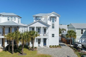 A row of white two-story houses with a central building featuring a balcony. - 7BR Heart of Home W Pool Near the Beach (Miramar Beach)