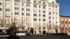 Un immeuble à plusieurs étages, doté de grandes fenêtres et d’une entrée centrale.