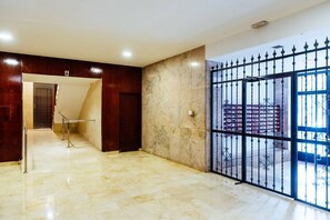 A hotel lobby with a marble floor, a staircase, and a metal gate. - Spacious apartment on the beach for 6 people (València)