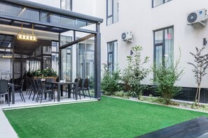 Un espace extérieur aménagé avec une structure vitrée, une table à manger et des chaises.