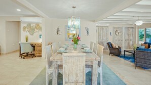 Un coin repas avec une table en bois rustique, des chaises et un lustre.