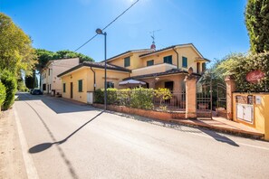 A two-story house with a balcony, a street lamp, and a gate.